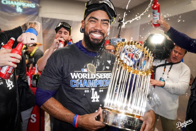Teoscar Hernández smiles as he holds the World Series trophy.