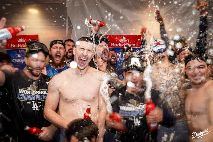 Walker Buehler celebrates with the bullpen with beer and champagne being sprayed in the clubhouse.