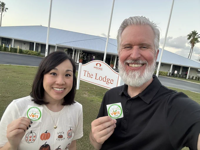 Katie and Steven holding I Voted stickers outside The Lodge
