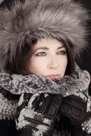 Kate Bush in various items of winter clothing, including a pair of snow-covered gloves