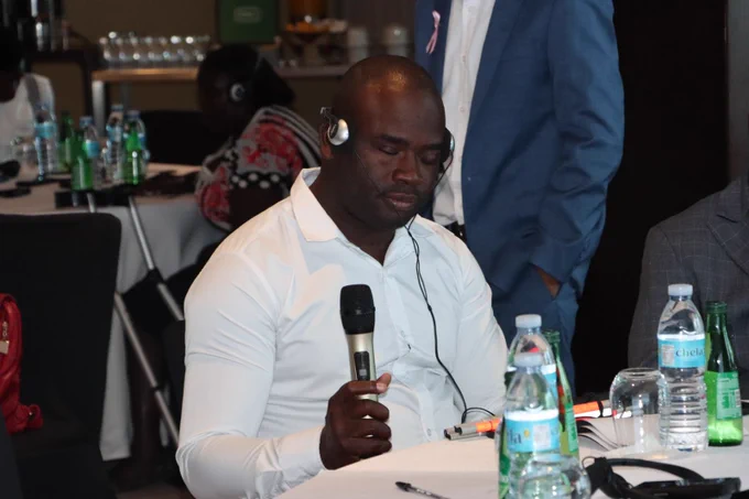 Male participant who is blind seated at a table listening.