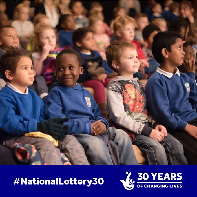 A photo of children enjoying a Christmas show at Northern Stage. Text reads #NationalLottery30 30 Years of Changing Lives