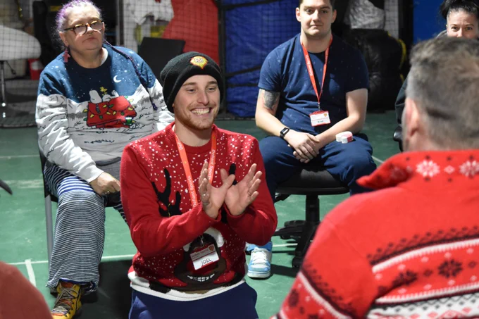 Coach Joel in the middle of a circle playing a party game at last year's festive party.