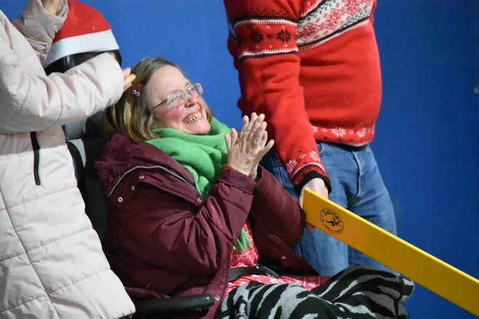 A player smiling wide and clapping their hands at last year's festive party.