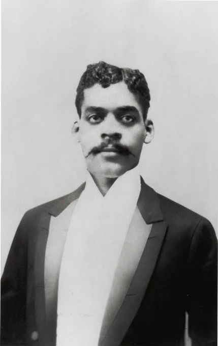A mid-legnth photo of Arturo Schomburg wearing a tuxedo. 