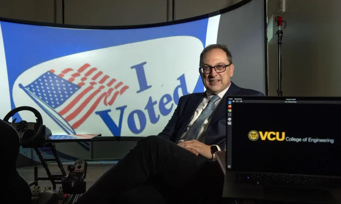 Portrait of Milos Manic, Ph.D., director of VCU's Cybersecurity Center, with a backdrop that is a photo of an "I Voted" sticker.