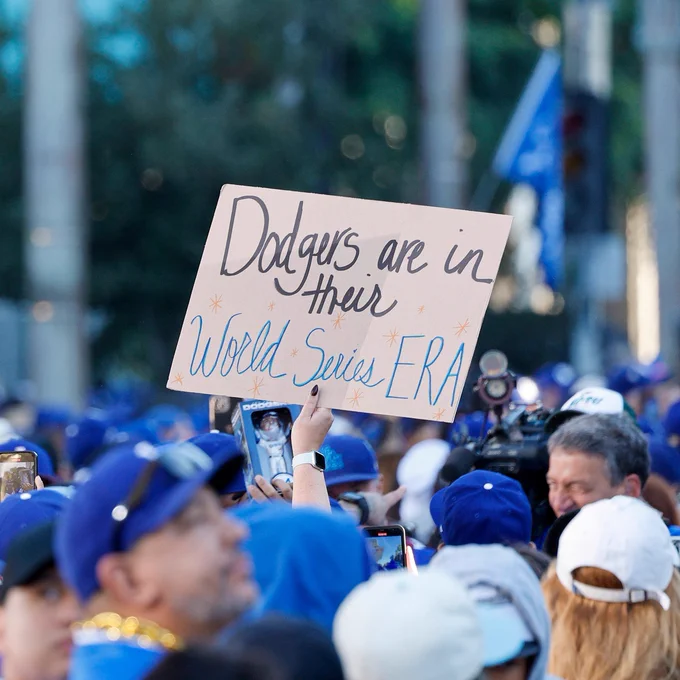 A fan holds up a sign reading "Dodgers are in their World Series ERA" in the crowd at the World Series parade.