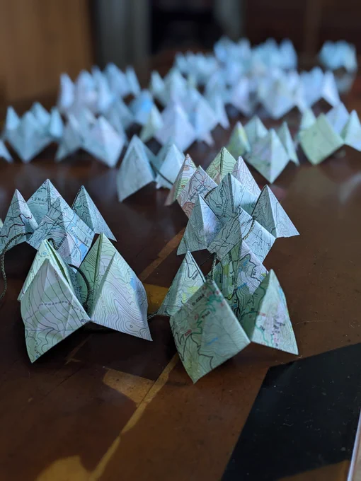 Trail Mix, 2024, by Allison Arth. A close-up of a field of origami fortune tellers made from trail maps.
