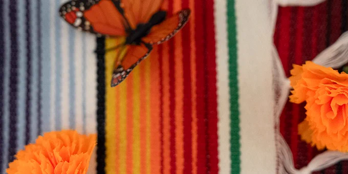 Flowers and fabric butterflies can be seen in a closeup of the tablecloth at the community ofrenda on the second floor of the Jacobs School.
