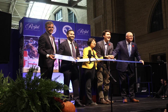 A group of people including the Mayor of Toronto, Olivia Chow, Prime Minister of Canada, Justin Trudeau, and the Ontario Minister of Agriculture, Food and Agribusiness, Rob Flack, ceremoniously cut a ribbon to mark the start of the 102nd Royal Agricultural Winter Fair.
