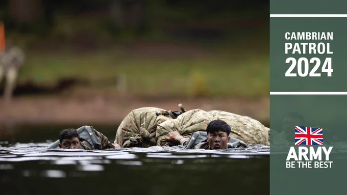 Two men in uniform swim across a river.
