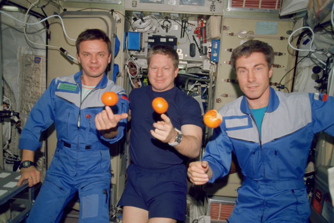 The first long-duration crew aboard the International Space Station, Expedition 1, is pictured in microgravity with fresh oranges. From left is Flight Engineer Yuri Gidzenko, Commander William Shepherd, and Flight Engineer Sergei Krikalev.