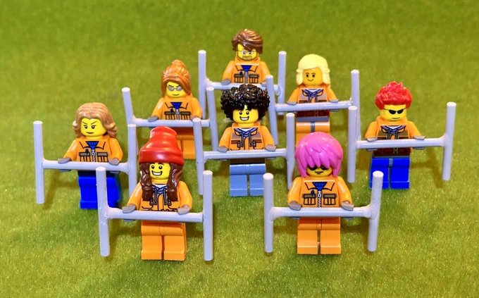 A photo of 8 Lego figures in high vis clothing holding Lego geophysical survey equipment.