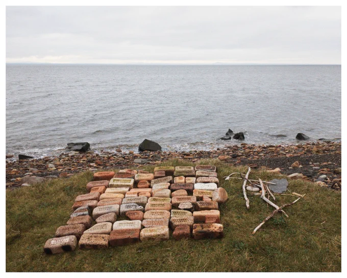 Colour photograph of many Prestongrange bricks laid out by the sea