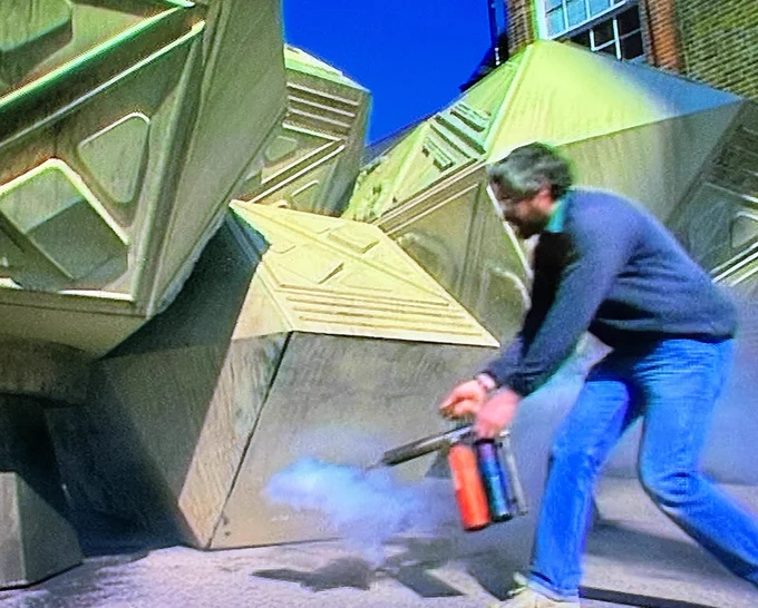 BBC Visual Effects technician Mickey Edwards sprays smoke from a smoke gun in front of a Dalek spacecraft in the Doctor Who story the Remembrance of the Daleks