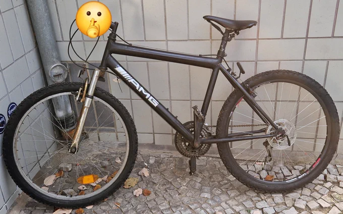 Nicht abgeschlossenes schwarzes Fahrrad vor gefliester Hauswand