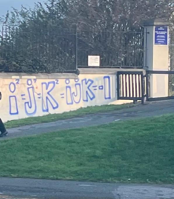 A wall spray painted with the quaternion relations.