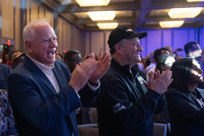 Governor Tim Walz and Second Gentleman Doug Emhoff clapping at Atlanta rally.