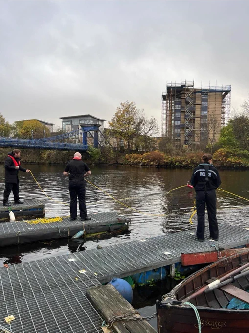 Police officer throwing rope into water