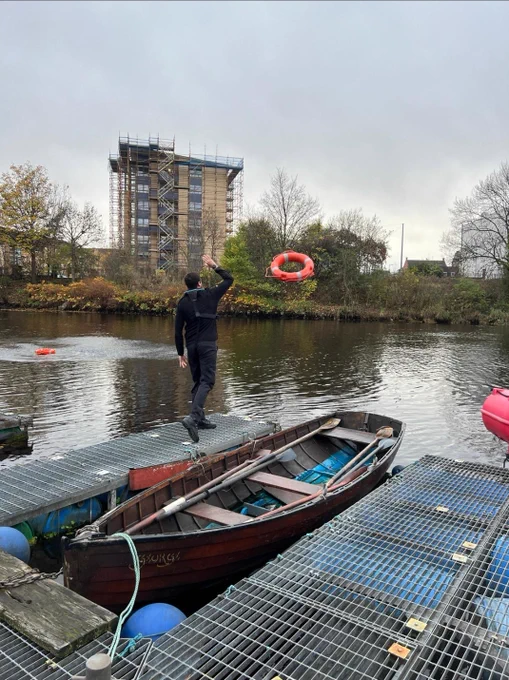 Police officer throwing rope into water