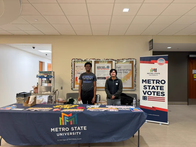 Image shows a Metro State Votes booth with two students smiling.