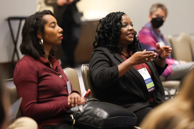 Two participants, one speaking, at QM Connect 2024.