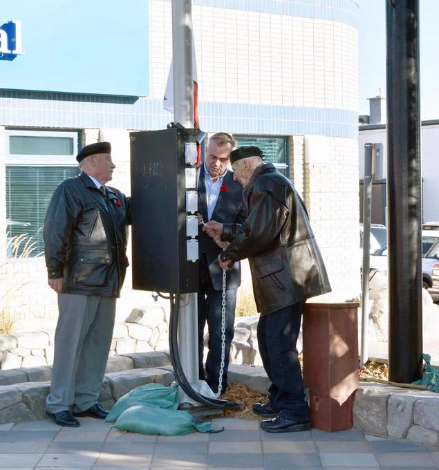 Swift Current Mayor Al Bridal (at centre) is assisted by Legion members Dave Boucher (at left) and John Watson during the raising of the poppy flag, Nov. 4.