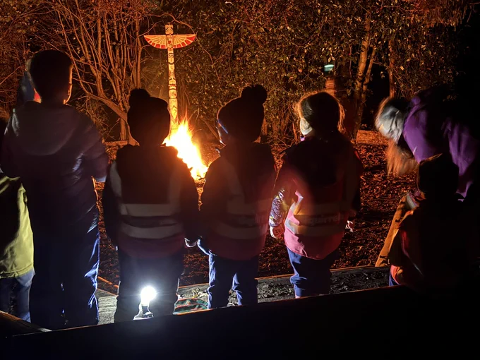 Group of Squirrel and Beaver Scouts in front of campfire