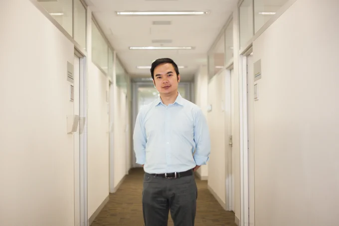 Associate Professor Quan Huynh standing in a hallway