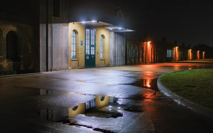 Art Deco facade of the waterworks along this building built in 1941, with mixed temperature lighting and puddle reflections.   