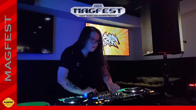 The photo for DJTaylorRae is displayed. They stand behind their hardware, adjusting the mix while performing. The dark room is contrasted by the LEDs on the decks and the television casting visuals.