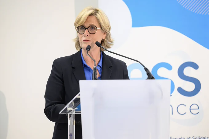 Marie-Agnès Poussier-Winsback au pupitre prononce son discours. En arrière plan, le kakémono bleu et blanc d’ESS France.