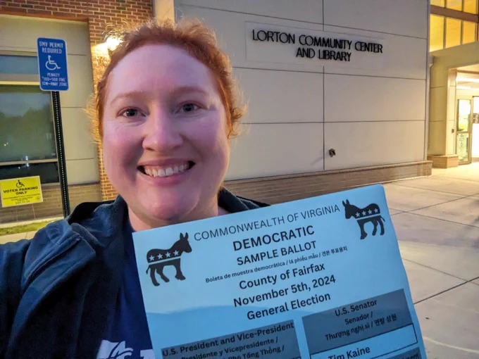 Me standing outside the Lorton Community Center holding a stack of democratic sample ballots.