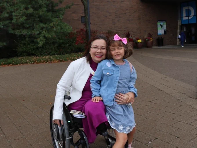 U.S. Senator Tammy Duckworth (D-IL) and her daughter are seen smiling together outside of an Illinois polling location.