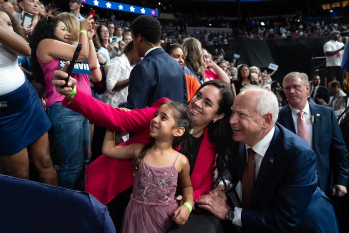 Governor Tim Walz takes a selfie with supporters.