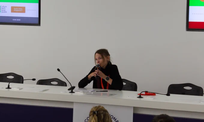La chercheuse, Sandra, est assise au centre de la table de conférence