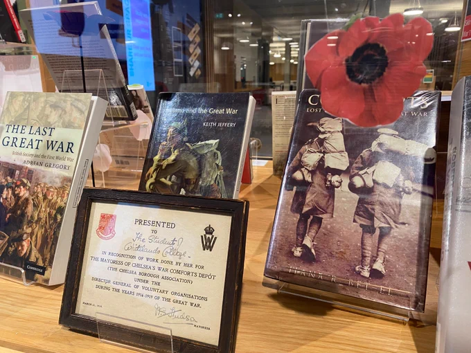 Image shows a closeup of the inside of the library Remembrance display with a Whitelands wartime archive item and some books