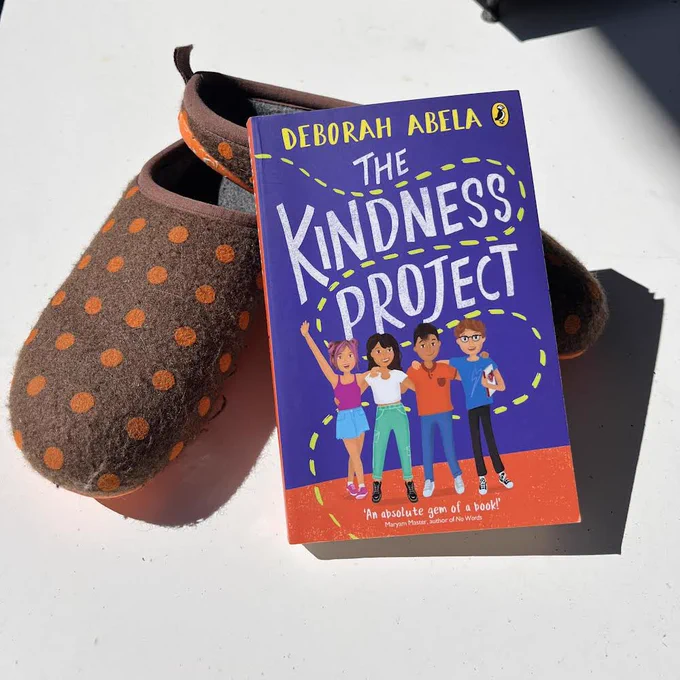 Book The Kindness Project posed against a spotted felt shoe