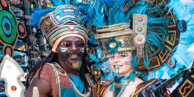 Two people posing in carnival outfits of blue and gold