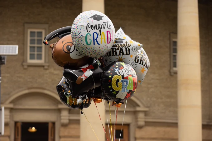 Cluster of graduation-themed celebration balloons raised outside of Convocation Hall.