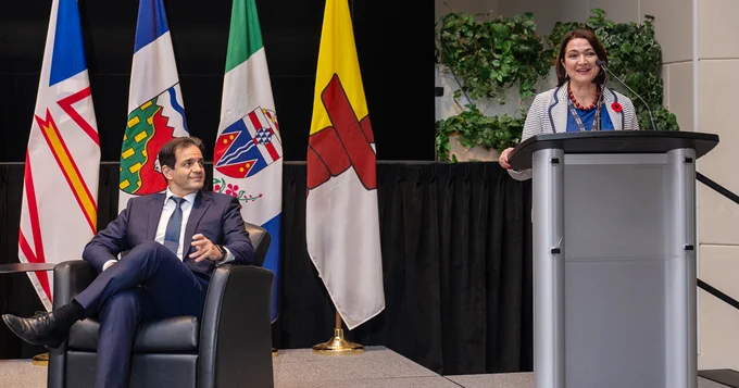 Giuseppina (Pina) D'Agostino, CIGI senior fellow and associate professor at Osgoode Hall Law School, Scientific Director of Connected Minds: Neural and Machine Systems for a Healthy Just Society, speaking into a podium with CIPO CEO, Konstantinos Georgaras sitting and listening.