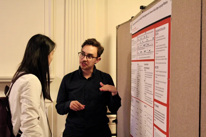 Researchers discussing iSchool research at their poster 