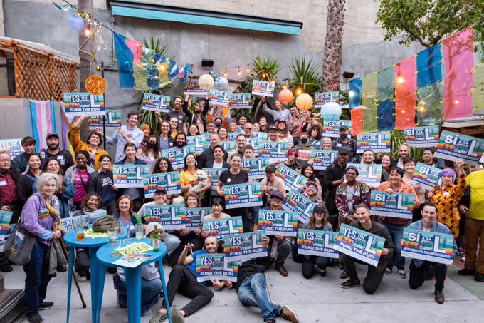Large group photo of 50  supporters holding Yes on L signs in a courtyard