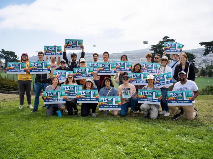 22 volunteers holding Yes on L signs