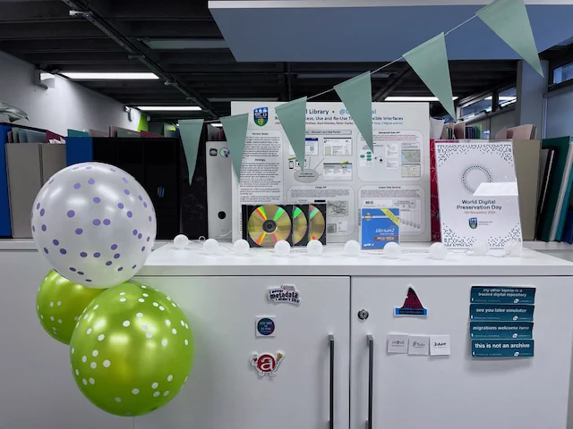World Digital Preservation Day 2024. Decorations surrounding a gold DVD and LTO tape.