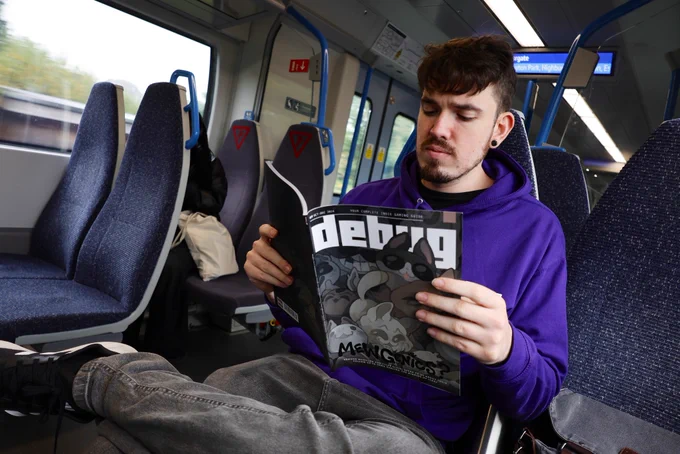 Nick from Debug Magazine reading Debug Magazine on a train
