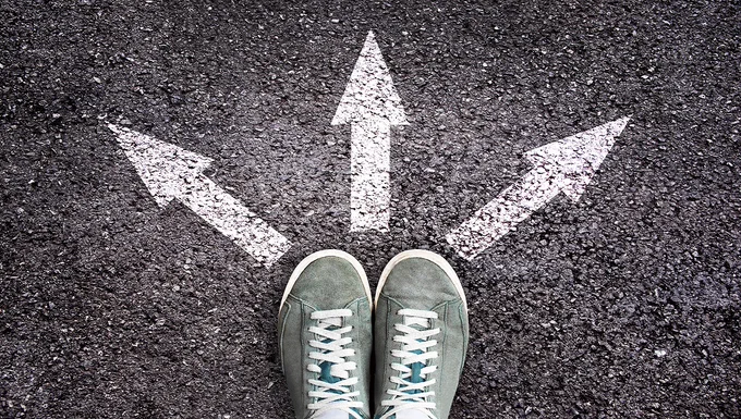 Stock image of 'choices' pair of shoes facing three arrows, left, straight ahead and right. 