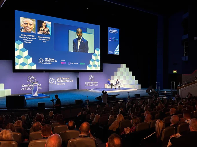 Sir Mo Farah CBE on stage with Ali Oliver at CST Annual Conference 2024.