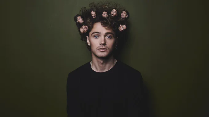 Henry Rowley against a dark green background with a straight face and lots of tiny images of his face in his hair.