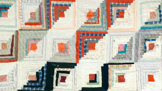 A close-up of the Kingston Log Cabin quilt that is made of multi-coloured square tiles patterned with diagonal lines